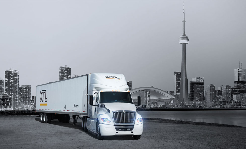 XTL transport truck parked, with city of Toronto in the background