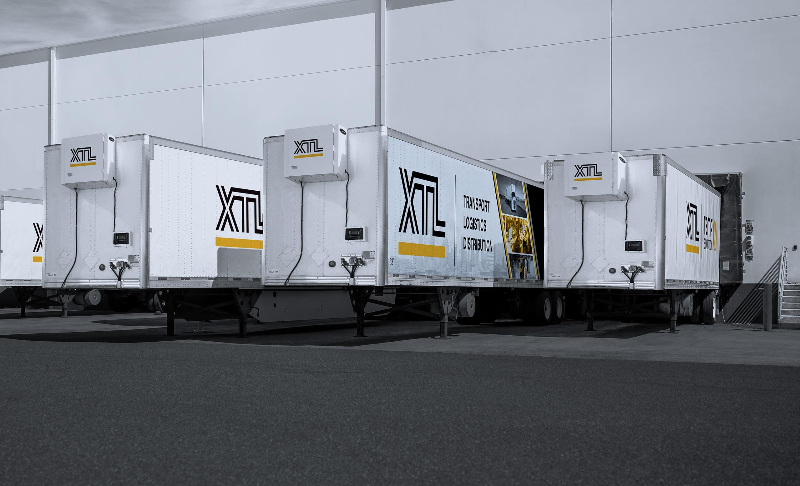 Multiple XTL heated trailers backed into a crossdocking, warehouse facility