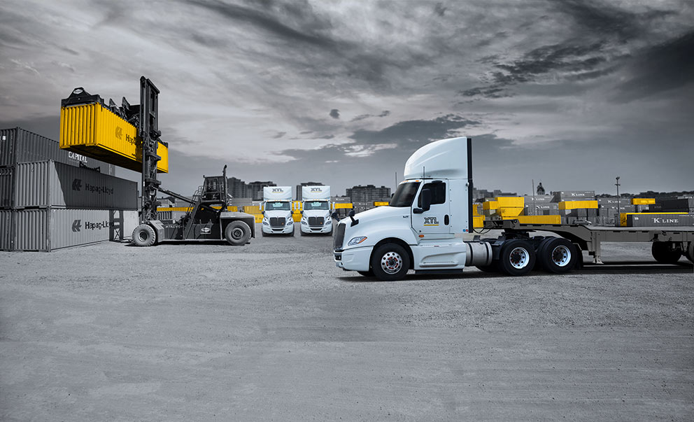 XTL day cab trucks in a container yard picking up containers for intermodal service