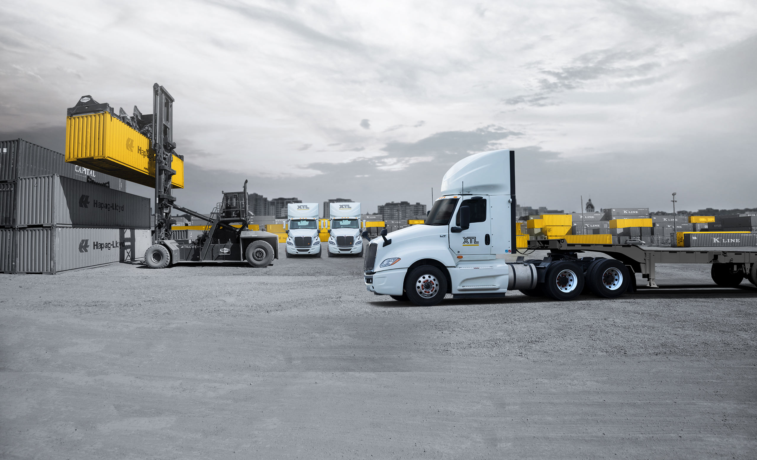 XTL day cab trucks in a container yard picking up containers for intermodal service