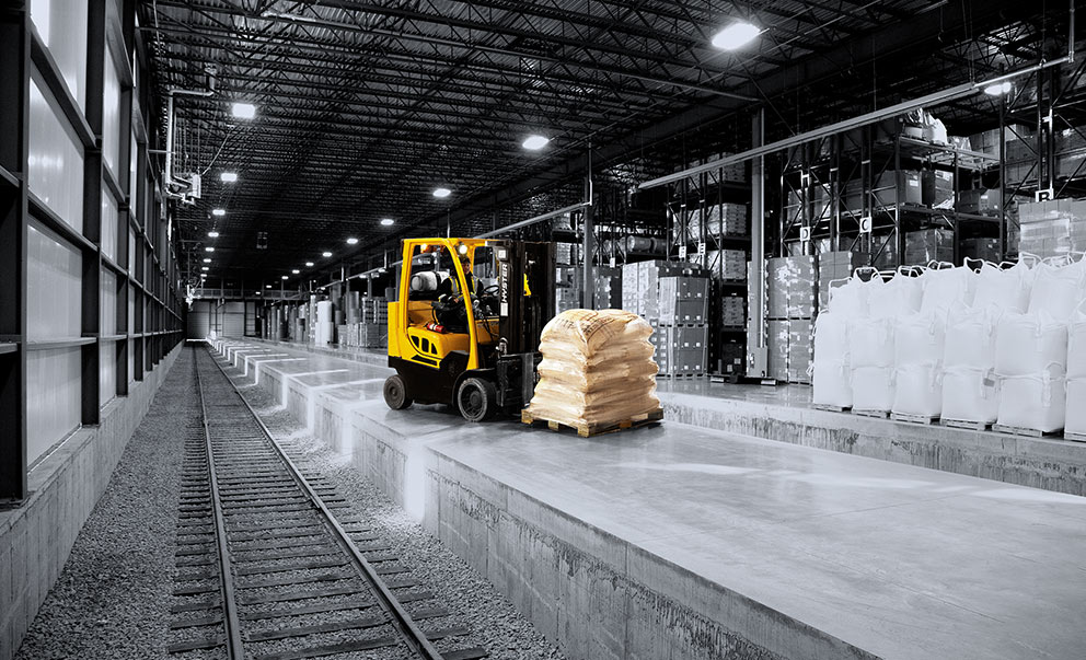 Forklift moving freight in a warehouse that has rail access inside building