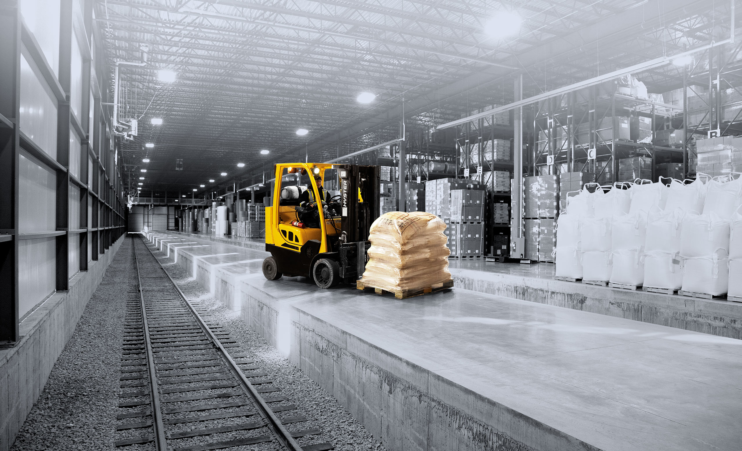 Forklift moving freight in a warehouse that has rail access inside building