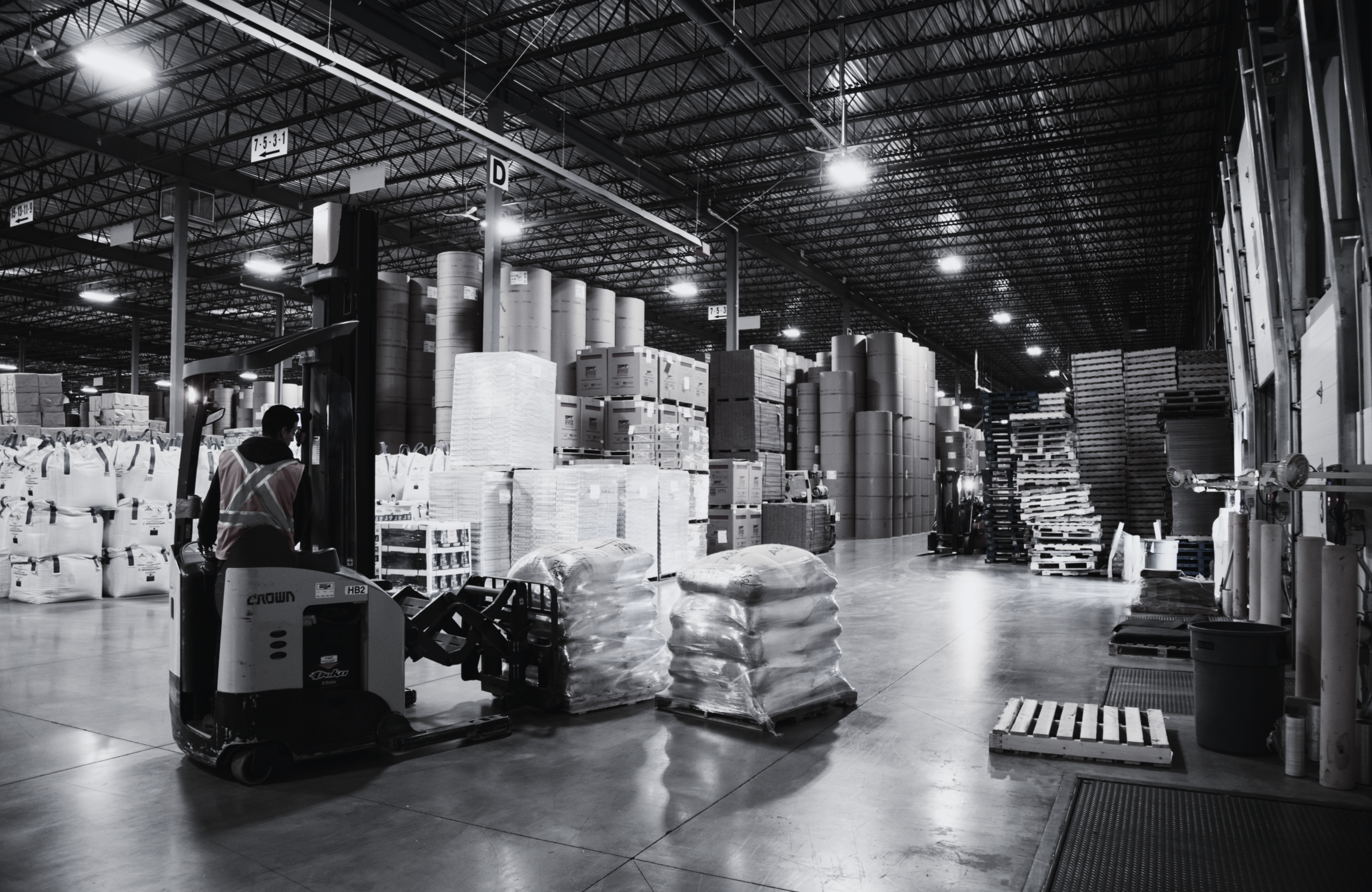 Forklift moving freight in a warehouse that has rail access inside building